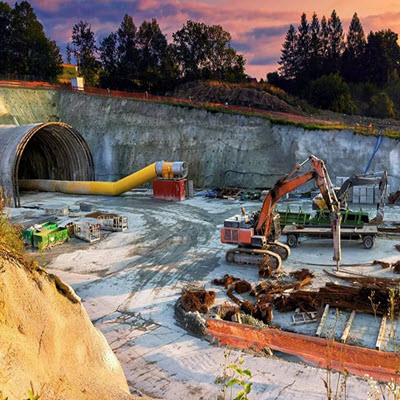 A construction site with machinery, including an excavator and equipment, near a large tunnel entrance. Trees and a colorful sky are in the background, while early adopters of OpenGround share user stories about the project's progress.
