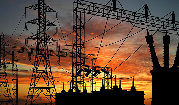 power lines and electrical station back lite from a sunset