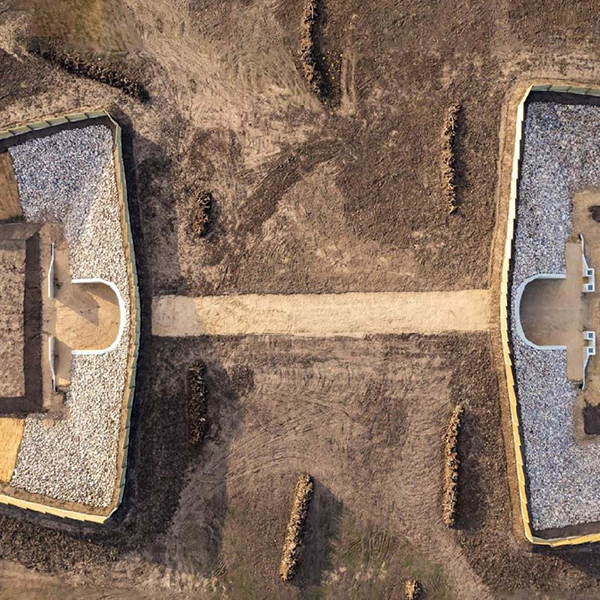 An aerial view of a building with a sand pit in the middle.