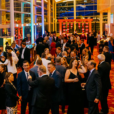 A group of well-dressed individuals engaging in conversation at an indoor social event.