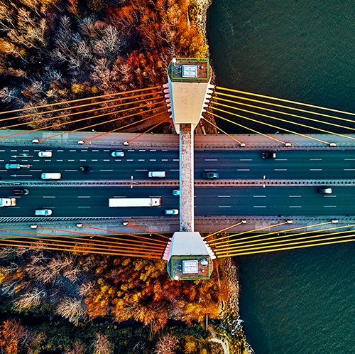 an aerial view of a bridge going a river with an overlapping green border | Bentley Systems | Infrastructure Engineering Software Company an aerial view of a bridge going a river with an overlapping green border